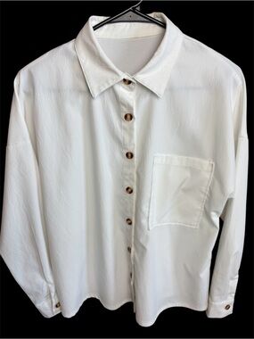 Women's long sleeve oversized white polyester button down blouse.